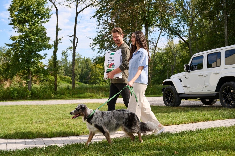 couple walking their dog after buying dog food