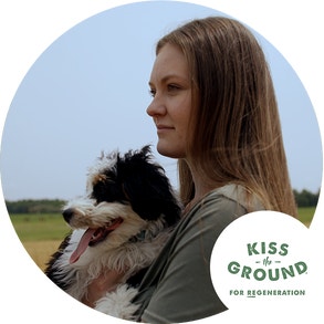 woman holding her dog with the Kiss the Ground logo