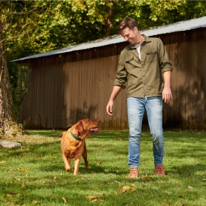 man walking with dog in yard