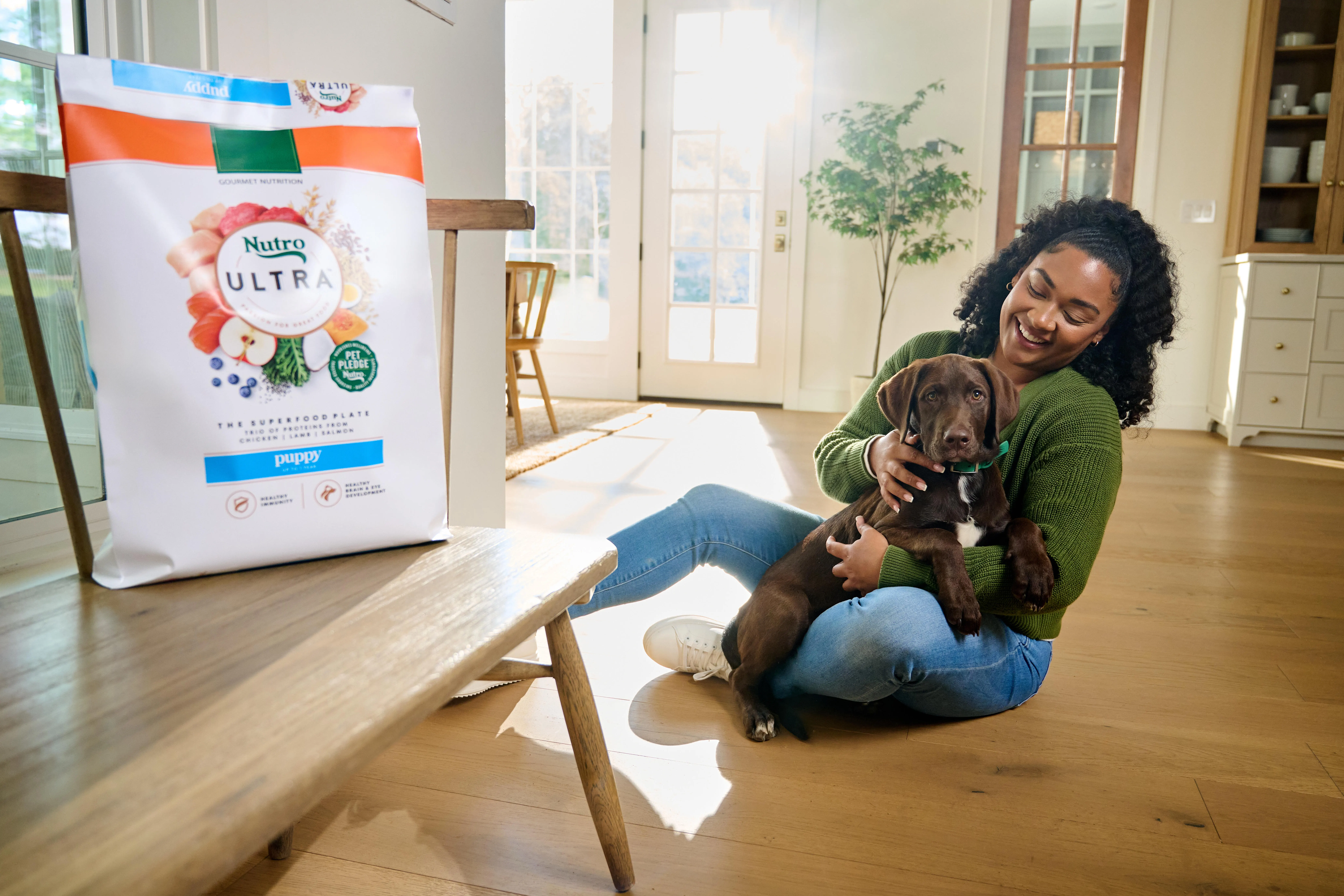 Woman with her dog and bag of NUTRO™ dog food
